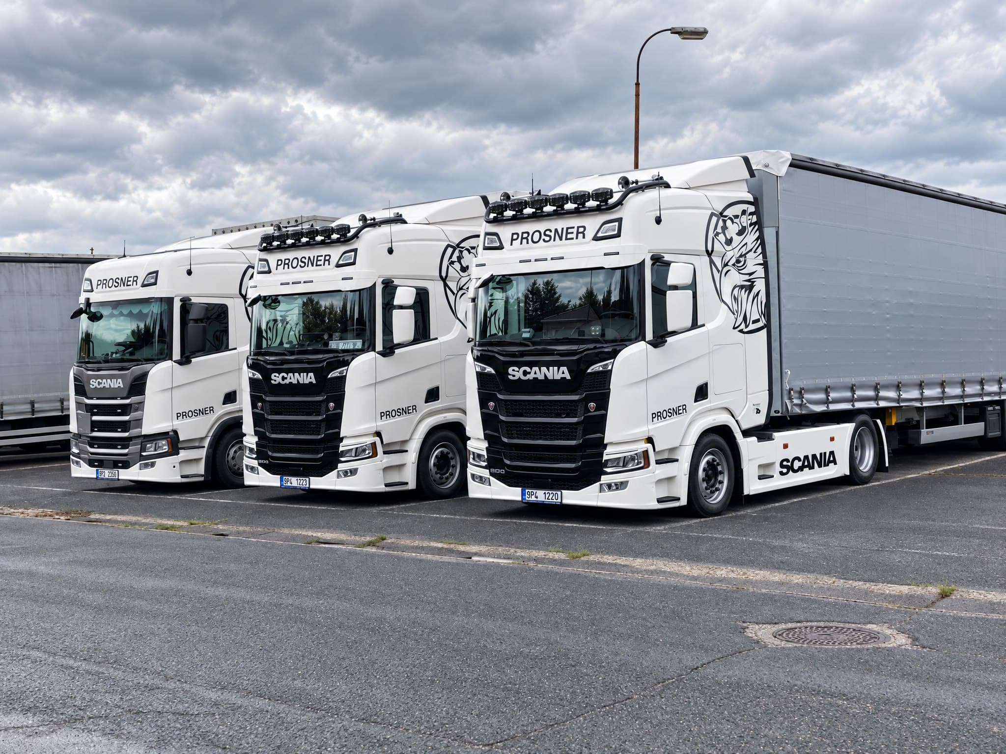Tři bílé tahače Scania s nápisem PROSNER zaparkované vedle sebe