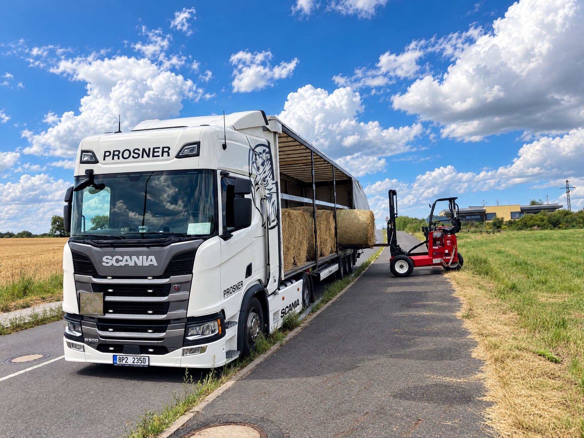 Souprava Scania R 500 PROSNER s odhrnutou plachtou při nakládce balíků sena