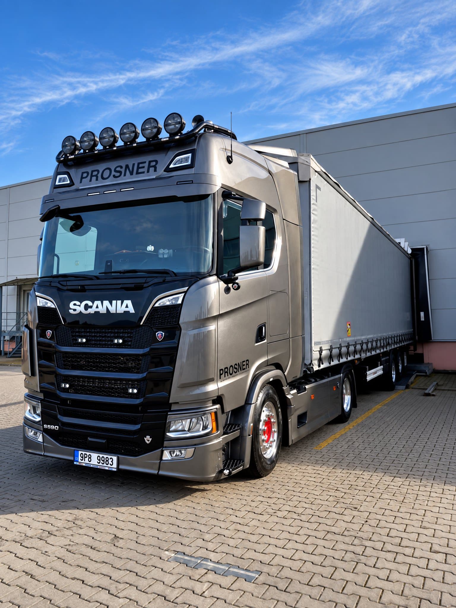 Antracitový tahač Scania S 590 PROSNER s plachtovým návěsem u nakládací rampy