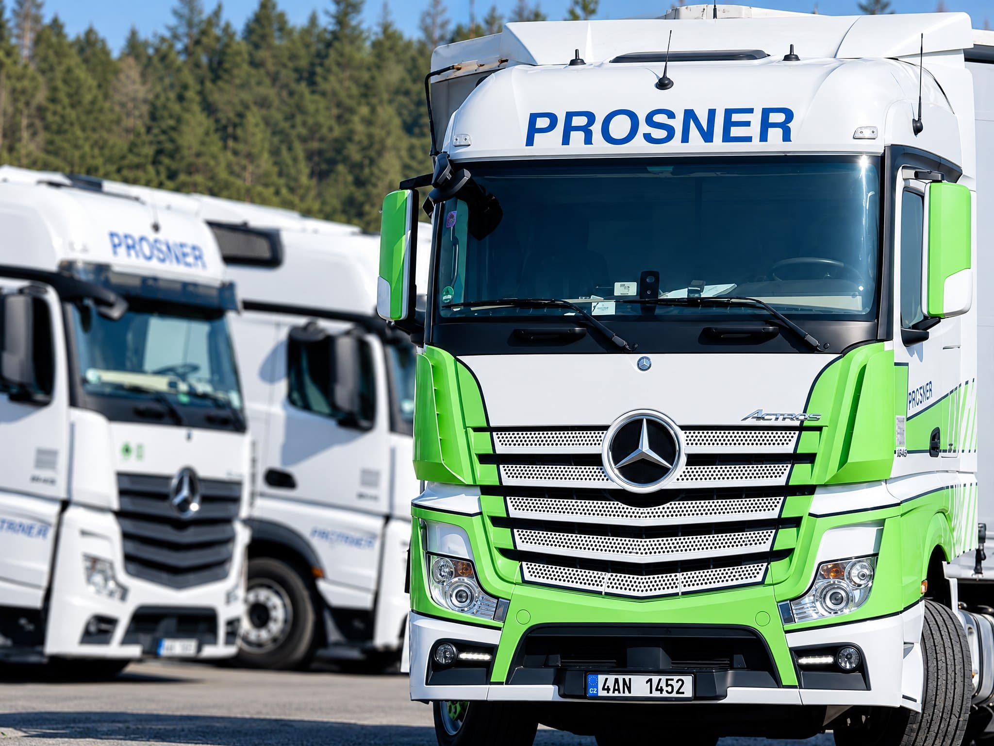 Starší tahače Mercedes-Benz Actros v bílo-zelených barvách s modrým nápisem PROSNER
